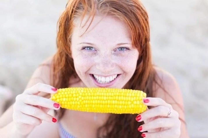 Девушка ест кукурузу