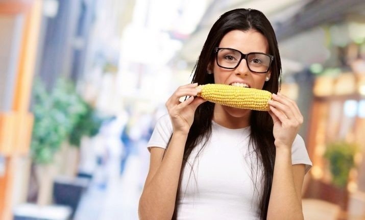 Девушка ест кукурузу